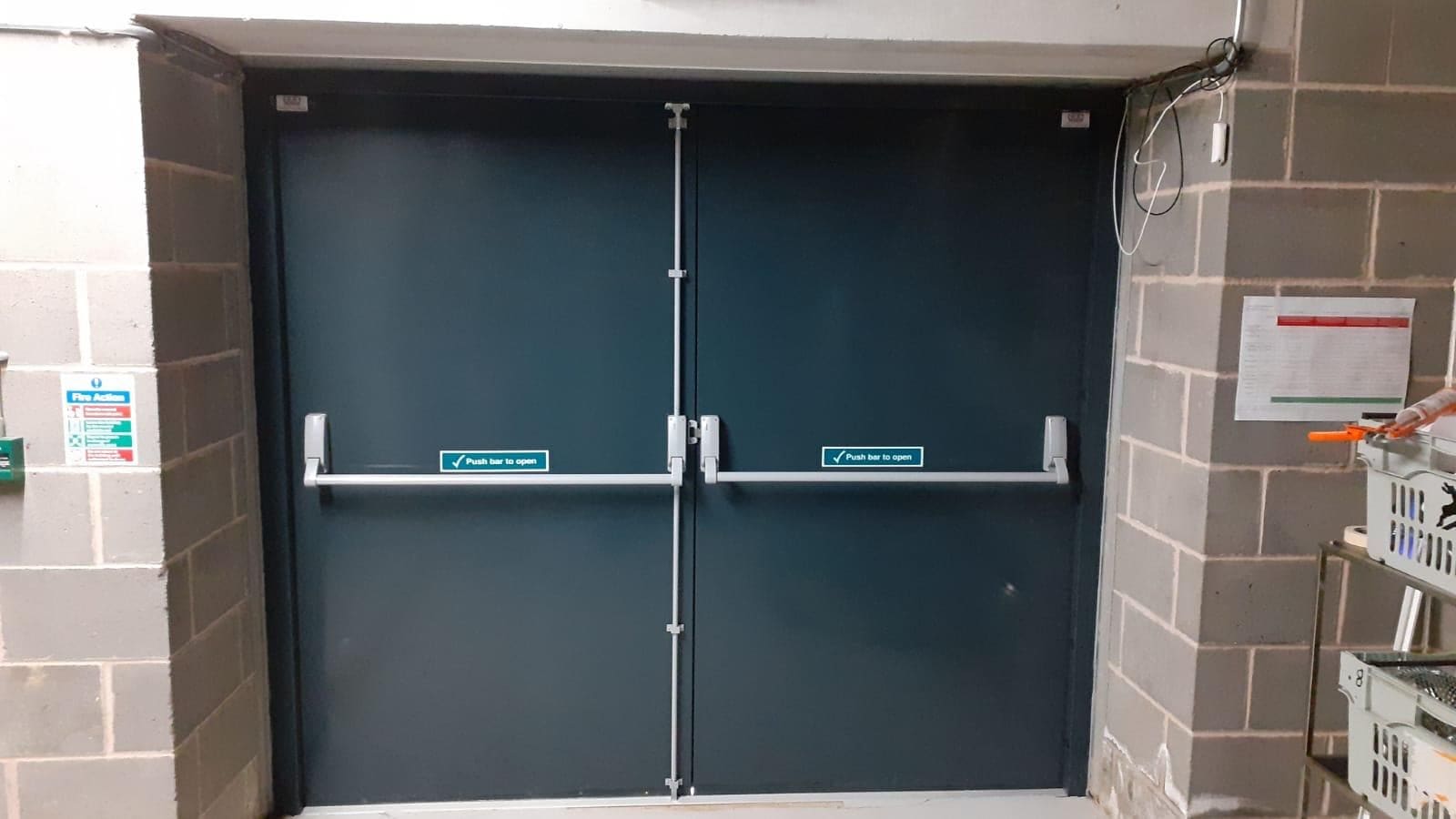 Commercial emergency exit fire door with teal push bar hardware
