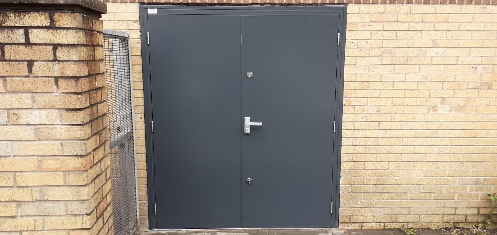 Emergency exit fire doors with green exit signage on commercial premises